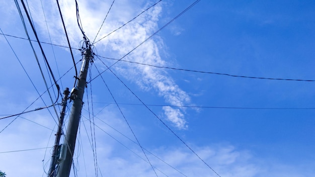 Messy power lines on a bright blue sky background