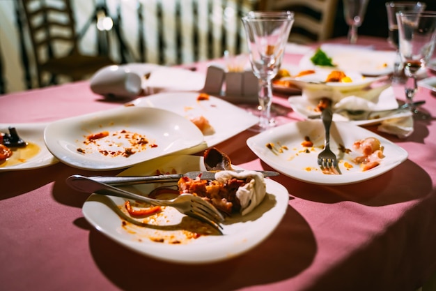 Messy table after party Leftover food spilled drinks dirty dishes