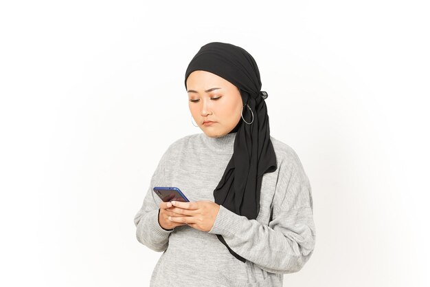 Met behulp van smartphone van mooie Aziatische vrouw die hijab draagt geïsoleerd op een witte achtergrond