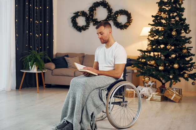 Met boek nieuwjaar komt eraan gehandicapte man in rolstoel is thuis