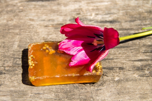 Met de hand gemaakte zeep en rode tulpenbloem op rustieke houten achtergrond