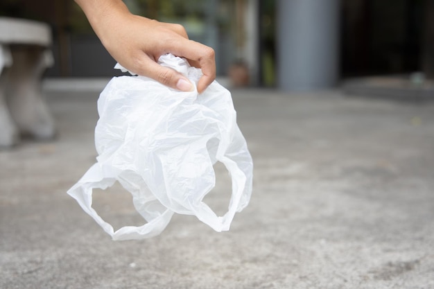 Met de hand oppakken van wegwerpafval in plastic zakken voor eenmalig gebruik