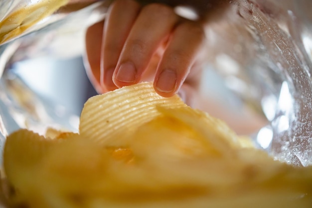 Met de hand plukken van chips in snackzak