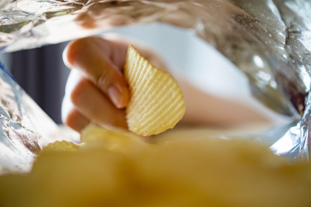 Met de hand plukken van chips in snackzak