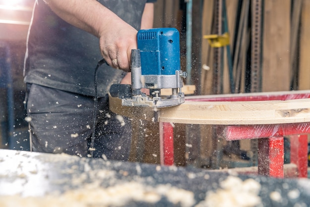 Met de hand rond houten venster malen elektrische snijder in schrijnwerkerij