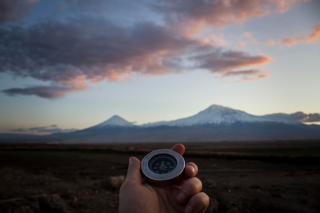 Met een kompas tegen de achtergrond van de berg Ararat bij zonsondergang
