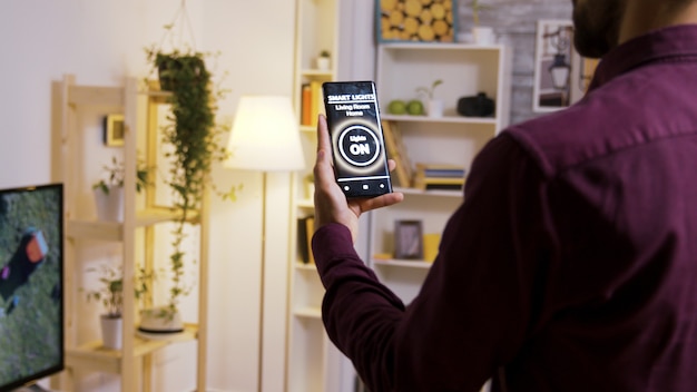 Met een smart light app zet je de lampen in huis aan. Close-up van slow motion-beelden