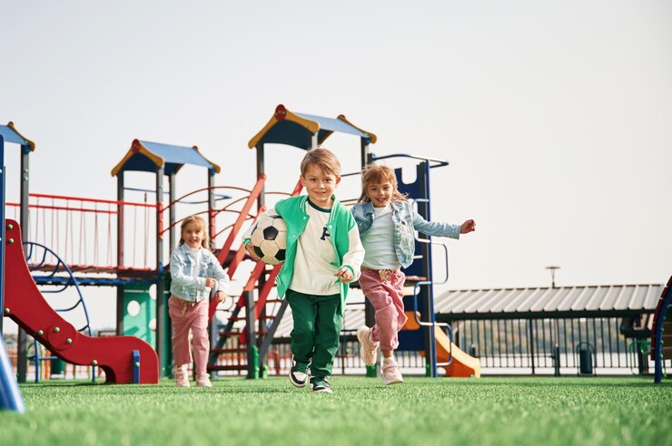 Foto met een voetbal in de hand lopen kinderen plezier maken op de speeltuin