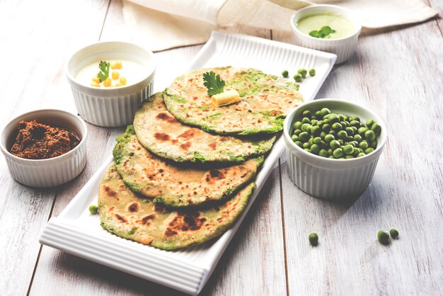 Met groene erwten gevuld plat brood of Matar ka Paratha is een traditioneel gerecht uit Noord-India. geserveerd met mango augurk, op humeurige achtergrond, selectieve focus