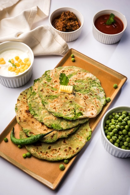 Met groene erwten gevuld plat brood of Matar ka Paratha is een traditioneel gerecht uit Noord-India. geserveerd met mango augurk, op humeurige achtergrond, selectieve focus