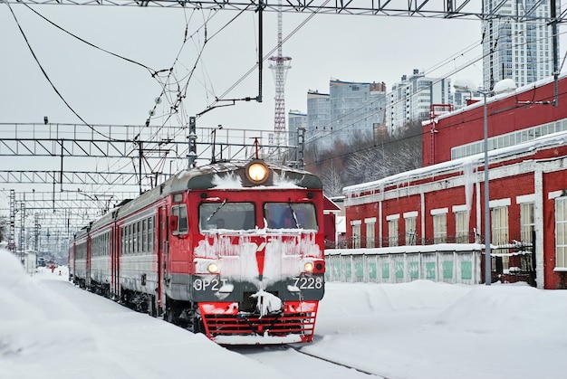 met ijs bedekte elektrische trein met meerdere eenheden voor passagiers op spoorwegknooppunt in de winter