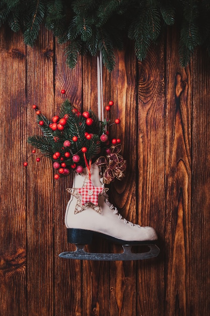 Met kerst versierde schaats op de houten muur