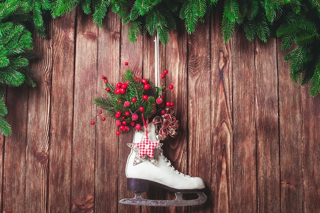 Met kerst versierde schaats op de houten muur