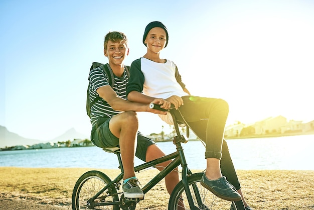 Met mijn broer een ritje maken Bijgesneden portret van een jonge jongen die zijn jongere broer een lift geeft op een fiets buiten