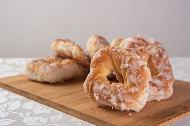 Met suiker bedekte zoete koekjes die op een gepolijst bord op een tafel met wit tafellaken, selectieve aandacht worden geplaatst.