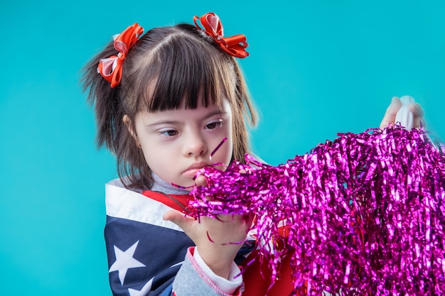 Met violette pompon. Vastbesloten kleine dame met een psychische aandoening die pomponmateriaal aanraakt tijdens de viering van 4 juli