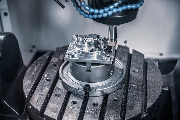 Metaalbewerking CNC freesmachine. Snijden van metaal moderne verwerkingstechnologie. Kleine scherptediepte. Waarschuwing - authentiek fotograferen in uitdagende omstandigheden. Een beetje korrel en misschien wazig.
