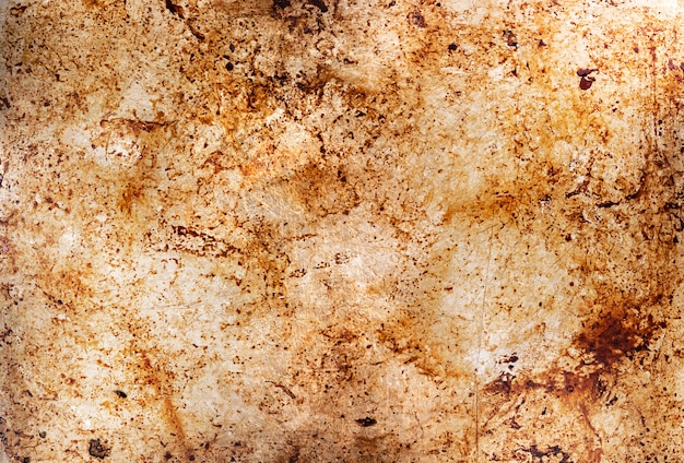 Металлический фон с масляными пятнами, грязный противень, смазанная поверхность противня с остатками масла после запекания