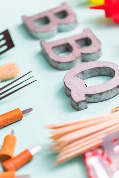 Metal BBQ sign with grilling tools.