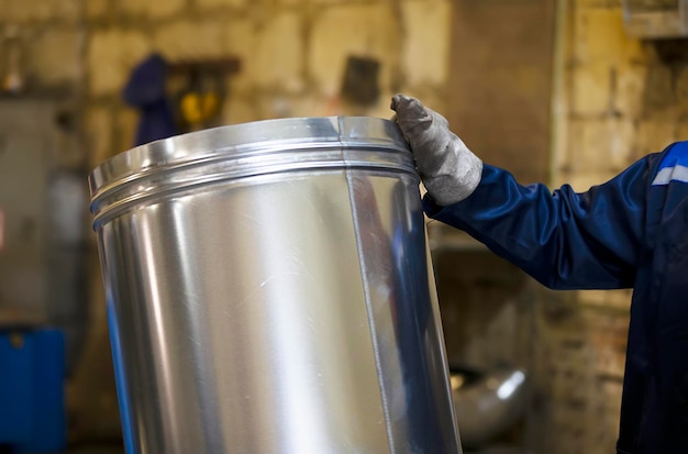 Metal Billet industry The hands of a worker hold a metal blank for pipes