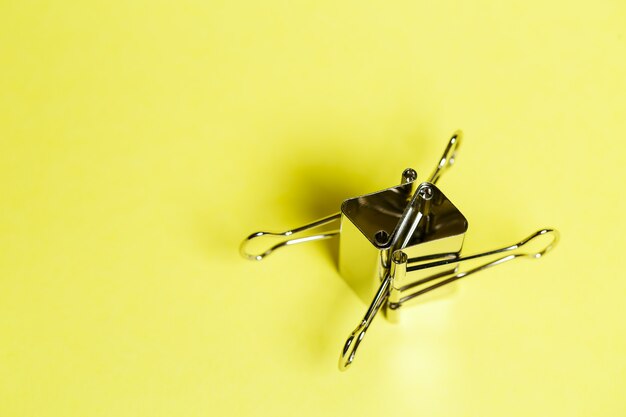 Photo metal binders on a yellow background. stationery accessories. paper clip