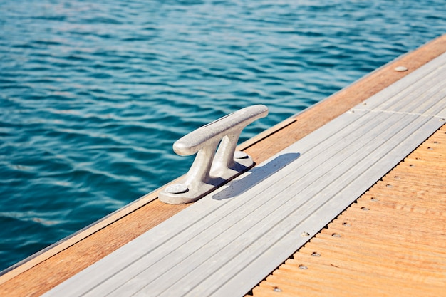 The metal bitt fairleads on a wooden pontoon