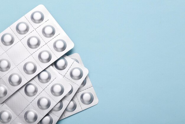 Metal blisters pills on a blue background Copy space Top view