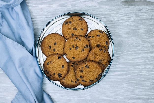 metal box of pieces of chocolate cookies on wood table