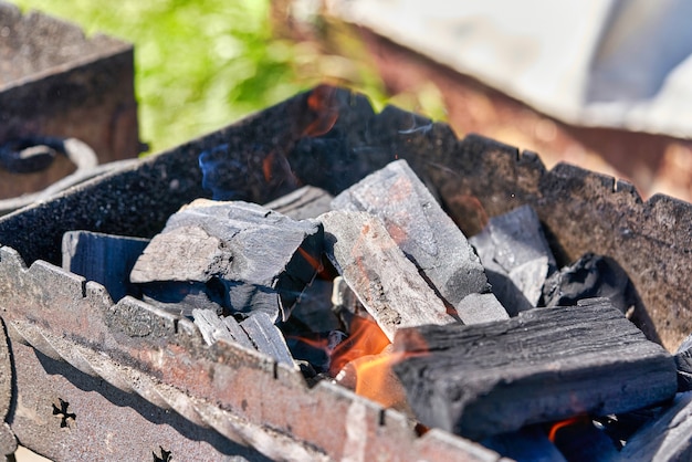 Metal brazier with black hot coals for cooking. Close up