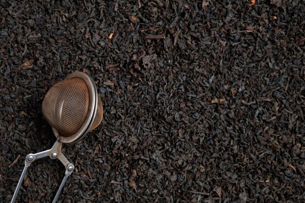 Metal brewing tool on black tewith copy space. Top view.