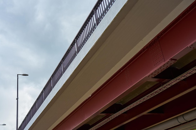 Вид на металлический мост снизу с пасмурным небом на заднем плане