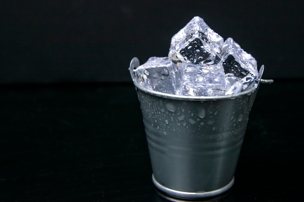 照片一个金属桶香槟的冰。孤立在一个黑色的