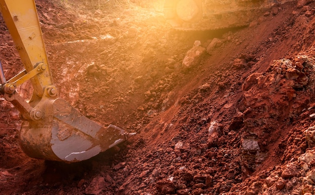 Фото Металлическое ведро экскаватора для копания почвы экскаватор, работающий на строительной площадке, выкапывая почву