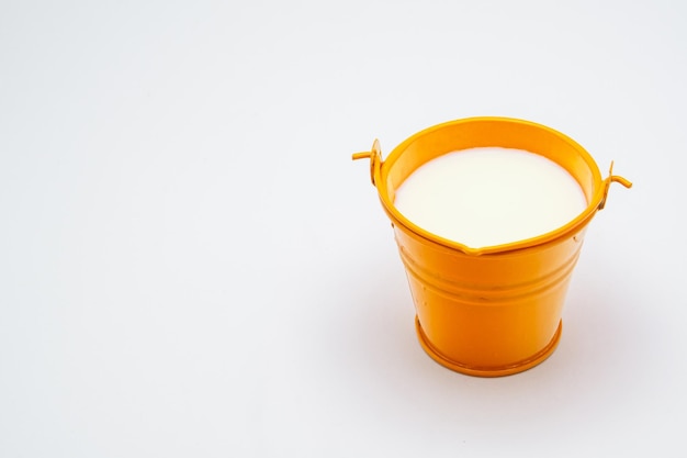 metal bucket with milk on white