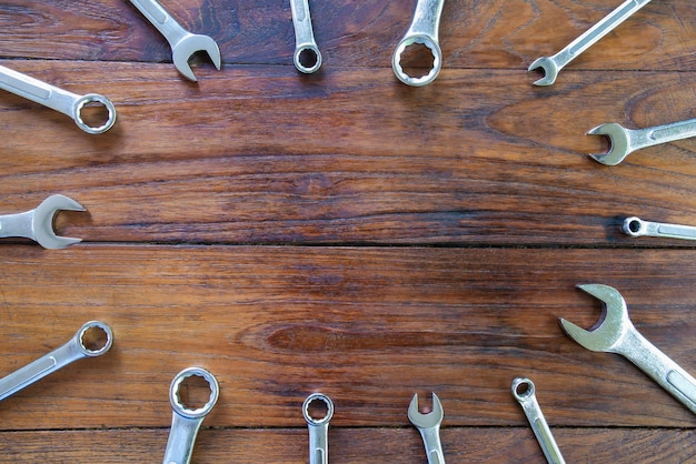 Metal bunch wrench tools lying on dark wooden background