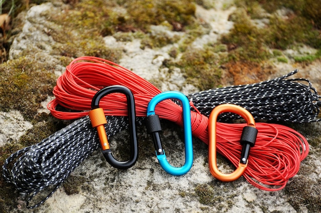 Metal carabine and rope for mountaineering. Photo of colored carabines and rope. Climbing concept