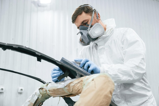 Foto il riparatore di carcasse metalliche sta lavorando nel garage.