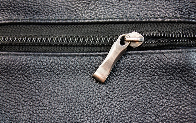 Metal clasp and zipper on the pocket of a leather purse or bag