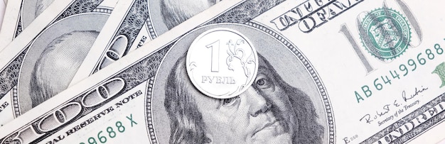 Photo metal coin 1 russian ruble lies on 100 us dollars a crisis economy currency exchange concept