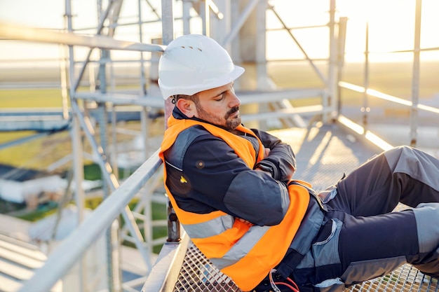 A metal construction worker sleeping on his workplace