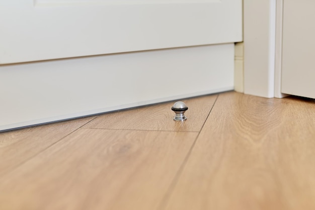 Metal door stopper built into wood floor