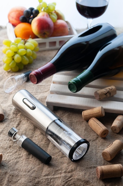 Metal electric corkscrew and vacuum stopper On a gray linen background