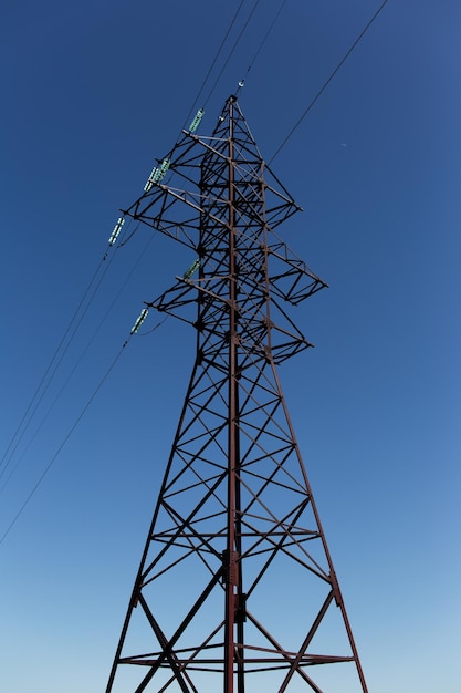 Metal electric tower of high voltage on background of blue sky