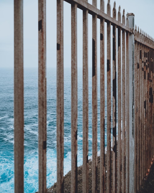 Photo metal fence by sea against sky