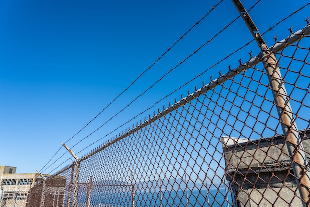 Metal fence with barbed wire on a restricted area