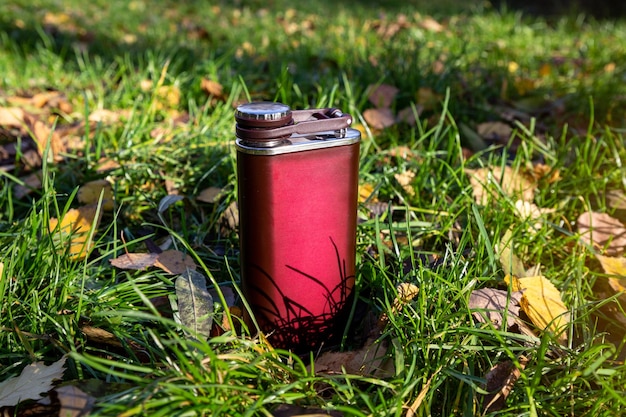 Metal flask for alcohol in the autumn forest Autumn walks Men's travel accessories