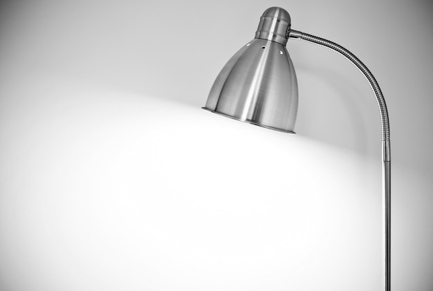 metal floor lamp standing near white wall