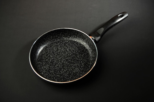 Metal frying pan Ceramic coating with nonstick coating Kitchen utensils On a black background Cooking for chefs in the kitchenA place for the textxA