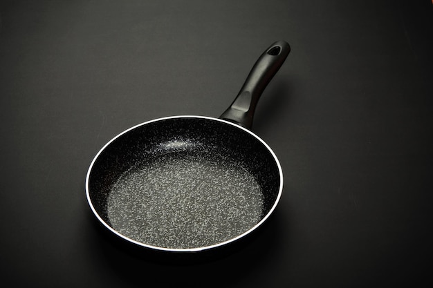 Metal frying pan Ceramic coating with nonstick coating Kitchen utensils On a black background Cooking for chefs in the kitchenA place for the textxA