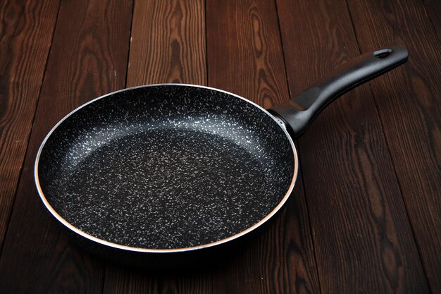 A metal frying pan Ceramic coating with nonstick coating kitchen utensilsOn a wooden background